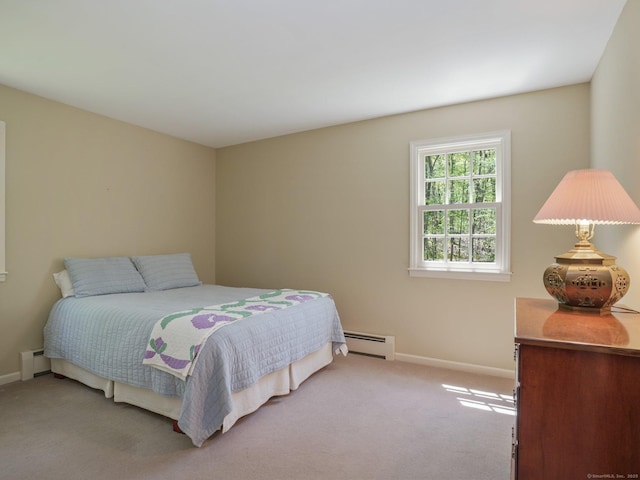 bedroom with a baseboard heating unit, carpet flooring, and baseboards