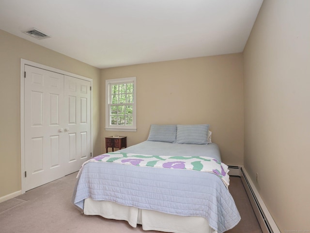 bedroom featuring baseboard heating, carpet flooring, a closet, and baseboards