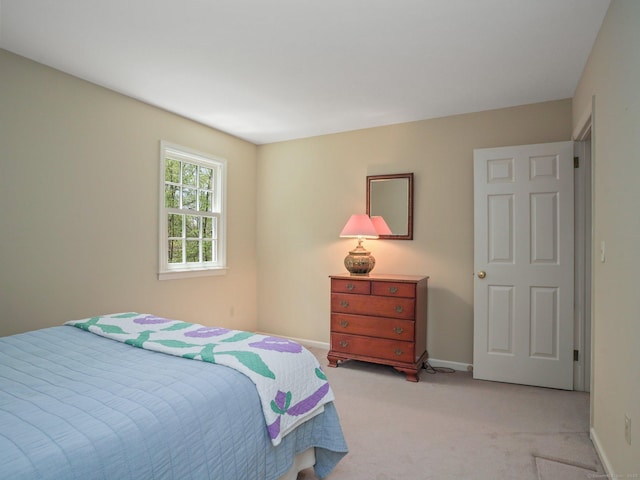 bedroom featuring light carpet and baseboards