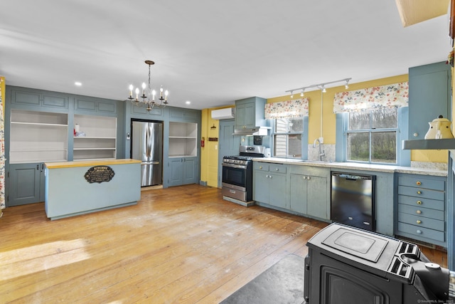 kitchen with open shelves, light countertops, a chandelier, a sink, and stainless steel appliances