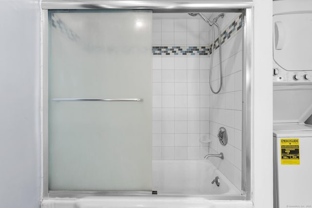 full bath featuring stacked washer and clothes dryer and combined bath / shower with glass door
