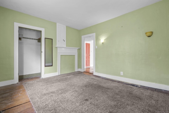 unfurnished living room with baseboards and wood finished floors