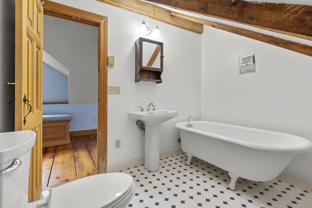 full bathroom with visible vents, a freestanding bath, a sink, baseboards, and toilet