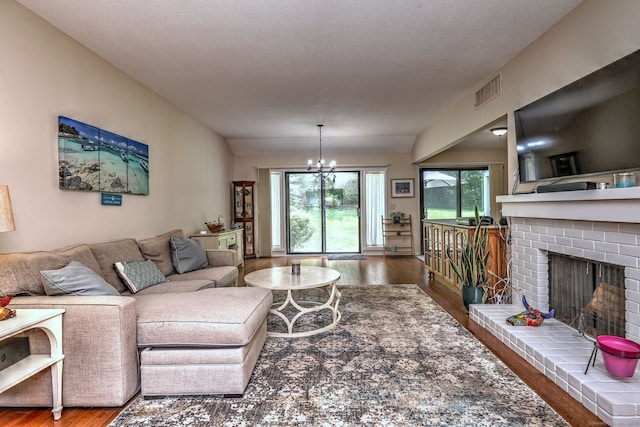 951 Heritage Vlg Unit B, Southbury, CT 06488 - living room featuring wood finished floors, a brick fireplace, plenty of natural light, and a chandelier