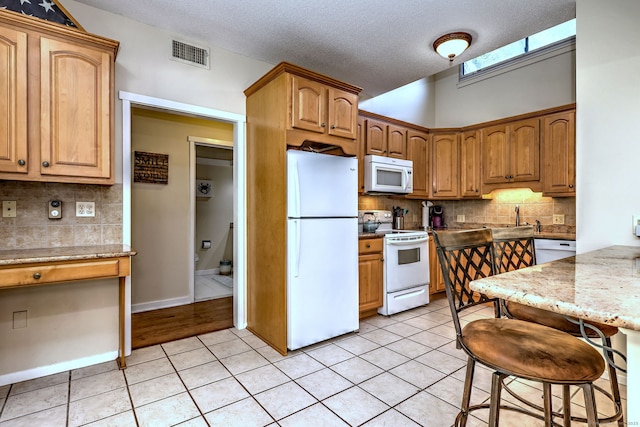 951 Heritage Vlg Unit B, Southbury, CT 06488 - kitchen with white appliances, tasteful backsplash, light tile patterned floors, light stone counters, and a textured ceiling