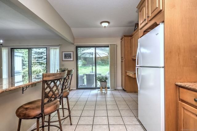 951 Heritage Vlg Unit B, Southbury, CT 06488 - kitchen with freestanding refrigerator, healthy amount of natural light, a kitchen breakfast bar, and light tile patterned floors