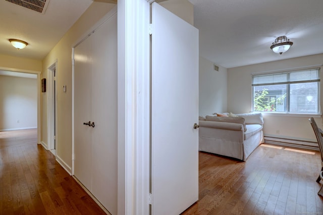 951 Heritage Vlg Unit B, Southbury, CT 06488 - hallway with wood-type flooring and a baseboard heating unit
