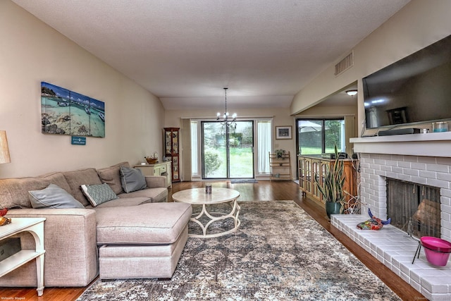 951 Heritage Vlg Unit B, Southbury, CT 06488 - living area with wood finished floors, a brick fireplace, plenty of natural light, and a chandelier