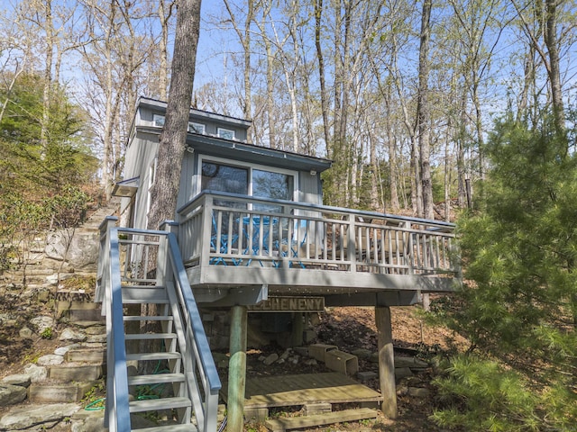 back of property featuring stairs and a wooden deck