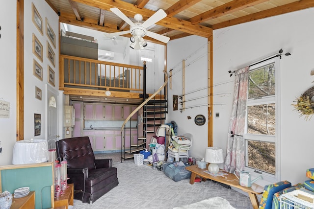 interior space featuring stairs, a ceiling fan, wooden ceiling, a towering ceiling, and beamed ceiling