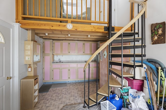 interior space featuring stairway, brick patterned floor, and a sink