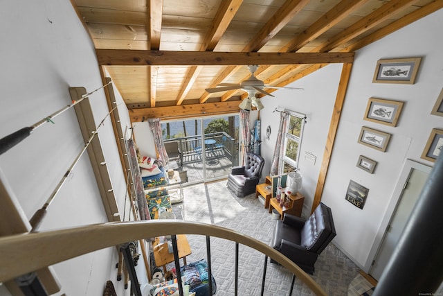 living area with a ceiling fan, carpet, wood ceiling, and beamed ceiling