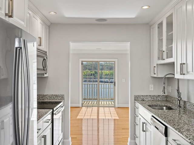 kitchen with a sink, white cabinets, stainless steel appliances, and recessed lighting