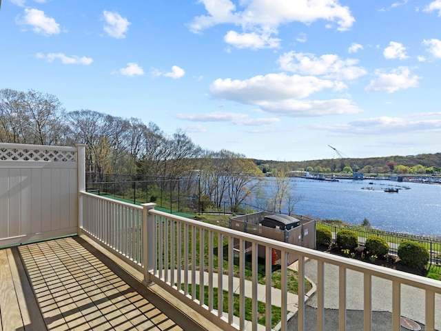 wooden terrace featuring a water view and fence