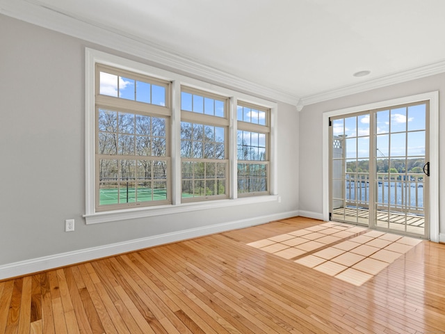 unfurnished room with baseboards, ornamental molding, wood-type flooring, and a water view