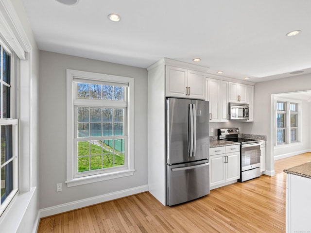 kitchen with white cabinets, appliances with stainless steel finishes, light wood finished floors, recessed lighting, and baseboards