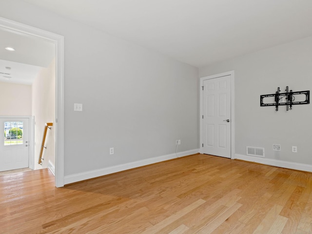 empty room with a notable chandelier, baseboards, visible vents, and light wood-type flooring