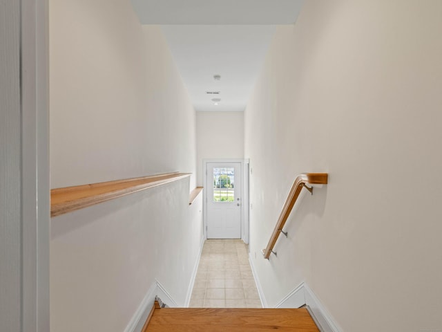 stairway featuring tile patterned floors and baseboards