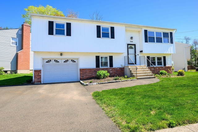 185 Daniel Rd, Hamden, CT 06517 - split foyer home with brick siding, a garage, a front lawn, and aphalt driveway