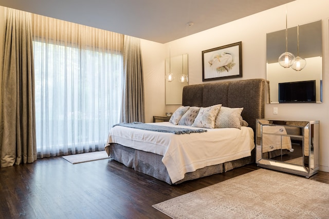 bedroom featuring wood finished floors and a chandelier