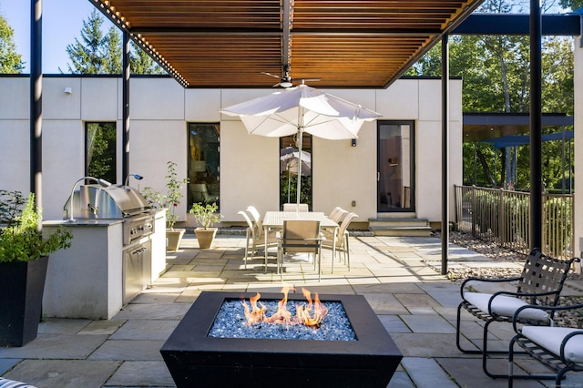 view of patio / terrace with outdoor dining area, a fire pit, exterior kitchen, and a grill