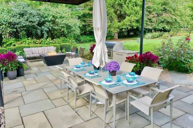 view of patio / terrace with outdoor dining space, exterior kitchen, an outdoor living space with a fire pit, and area for grilling