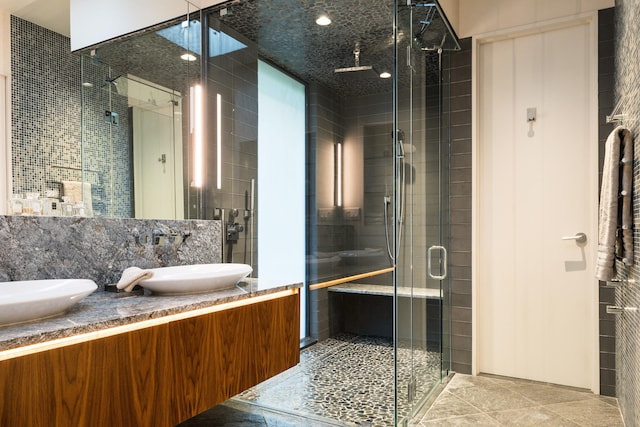 bathroom with backsplash, a shower stall, and vanity