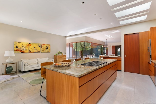 kitchen with a center island, light tile patterned floors, a breakfast bar, and stainless steel gas stovetop