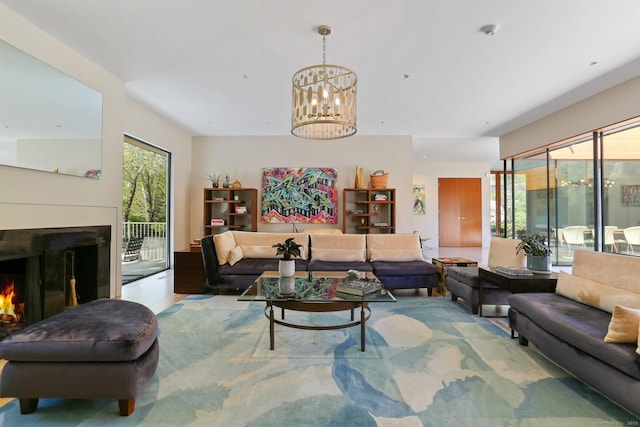 living area featuring a chandelier and a warm lit fireplace