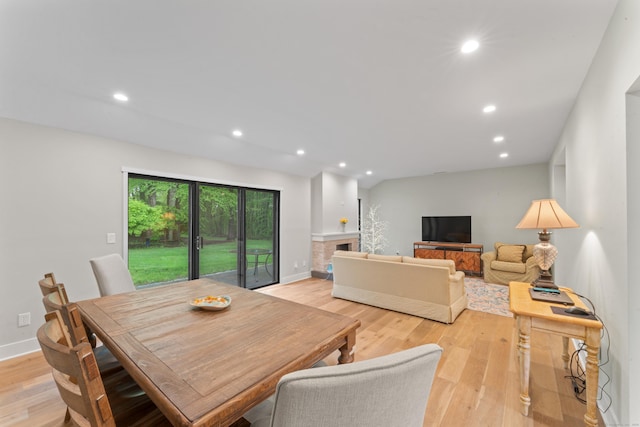 dining room with light wood-style floors, recessed lighting, and baseboards