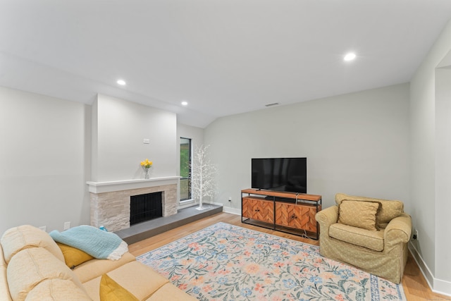 living room with recessed lighting, wood finished floors, baseboards, and a fireplace