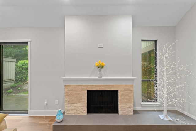 unfurnished living room featuring a fireplace, wood finished floors, and baseboards