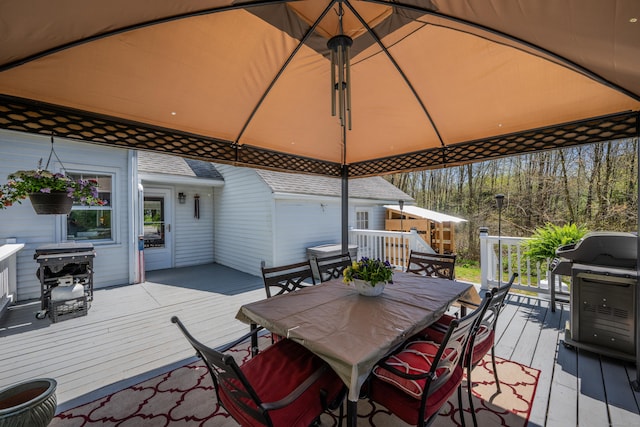 wooden terrace with outdoor dining area and grilling area