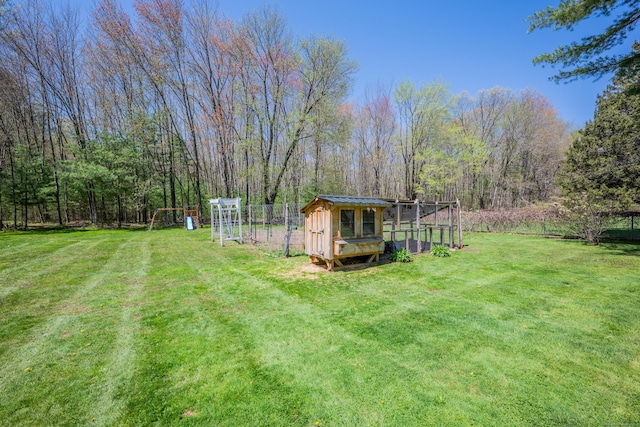 view of yard featuring exterior structure, fence, and an outdoor structure