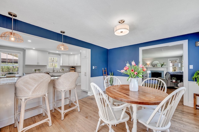 dining space with a fireplace and light wood-type flooring