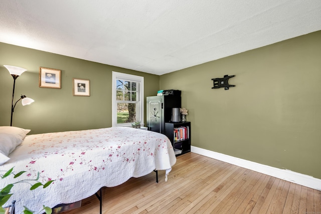 bedroom featuring baseboards and wood-type flooring