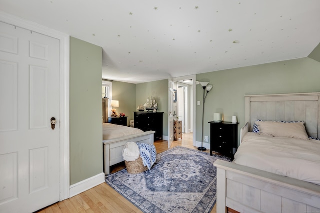 bedroom with light wood-style floors and baseboards
