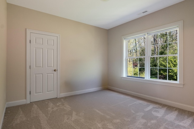 spare room with baseboards and carpet flooring
