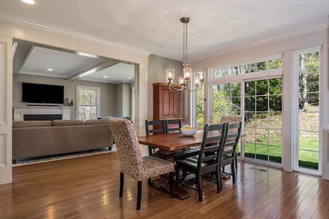 dining area featuring crown molding, visible vents, wood-type flooring, and a chandelier