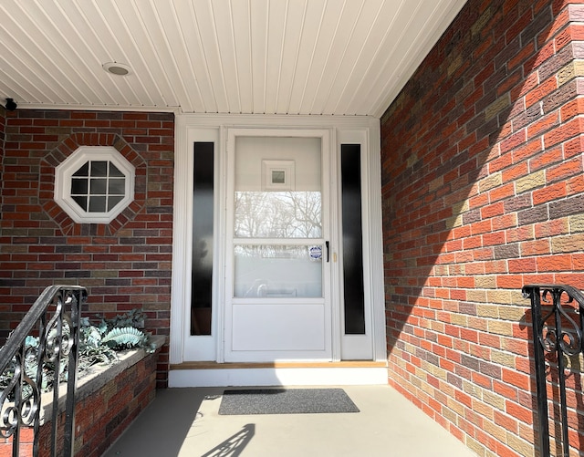 view of exterior entry featuring brick siding