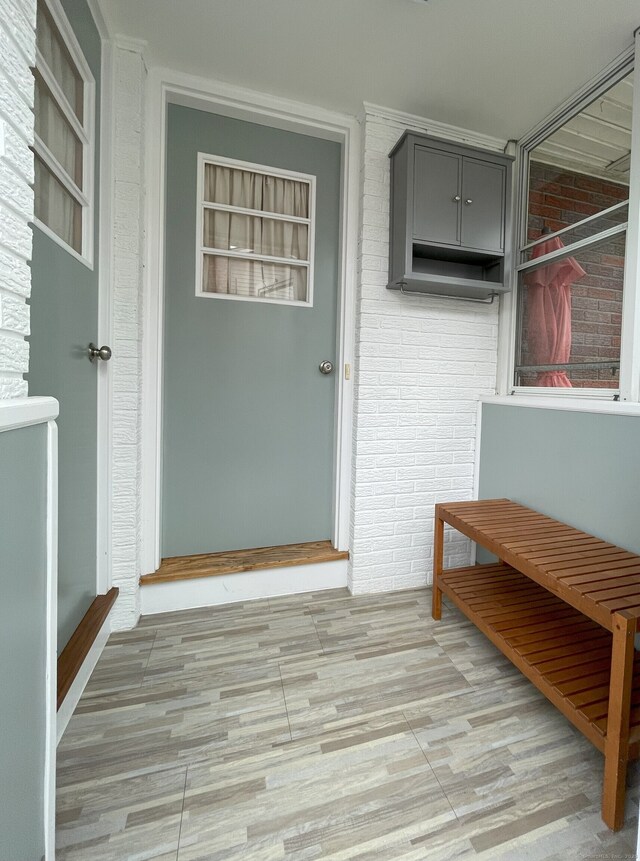 doorway to property with brick siding