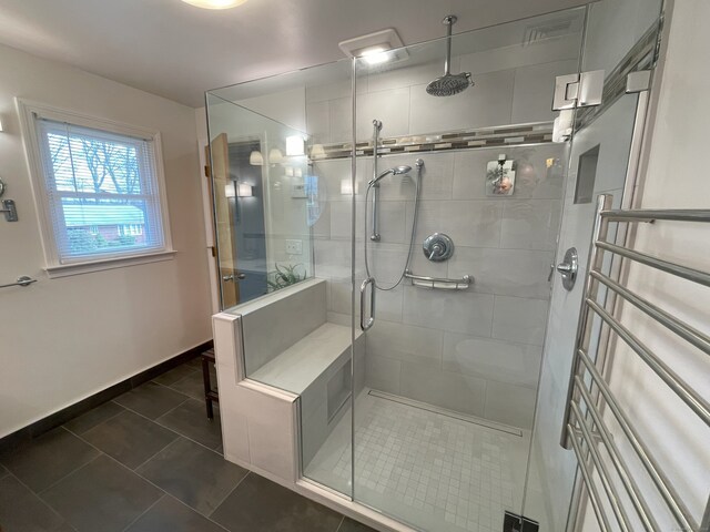 bathroom featuring a stall shower, tile patterned flooring, and baseboards