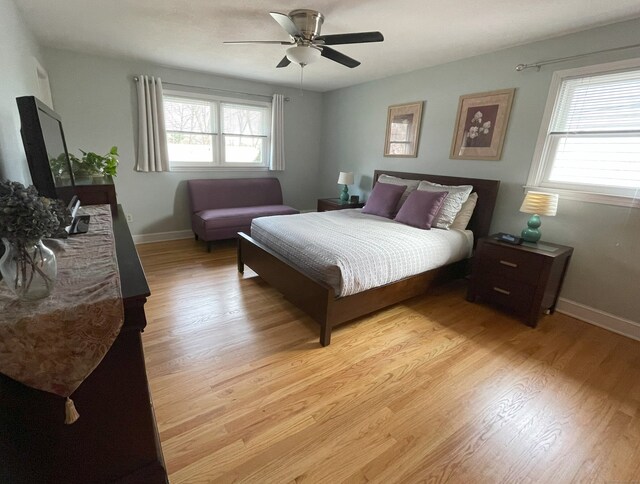 bedroom with light wood-style flooring, baseboards, and ceiling fan