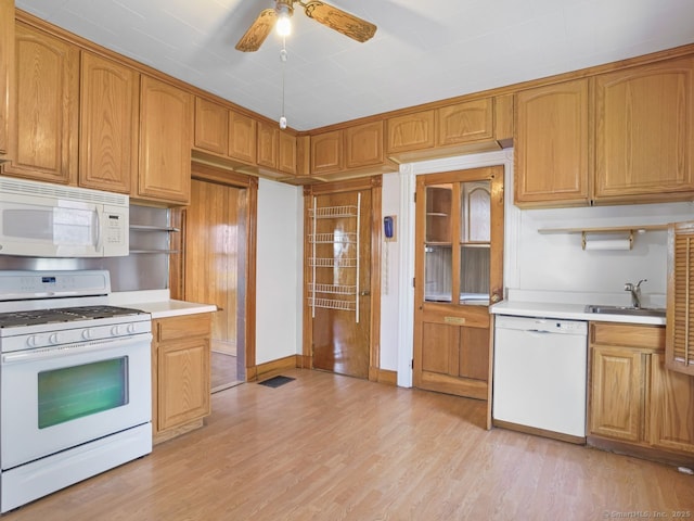 kitchen with a ceiling fan, white appliances, light wood-type flooring, light countertops, and a sink