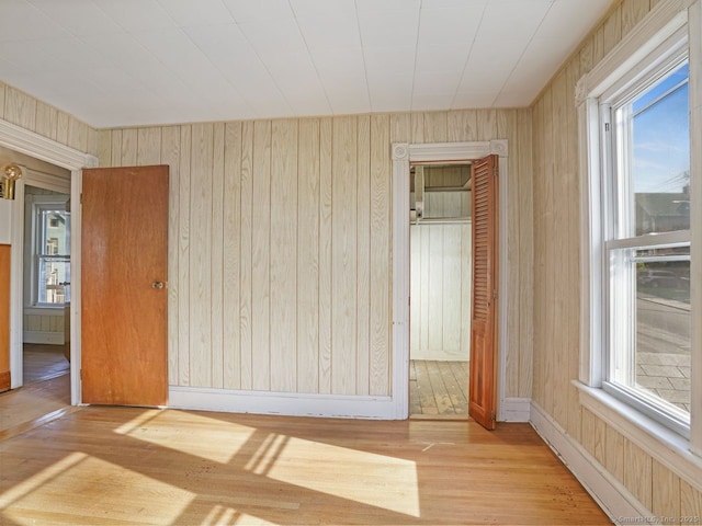 spare room featuring wood walls and wood finished floors