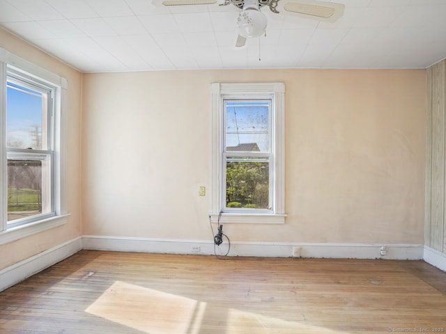 empty room featuring baseboards, a ceiling fan, and wood finished floors