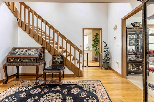 foyer with baseboards, stairway, and wood finished floors