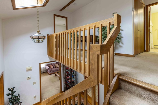 stairway with lofted ceiling with beams, carpet, and baseboards