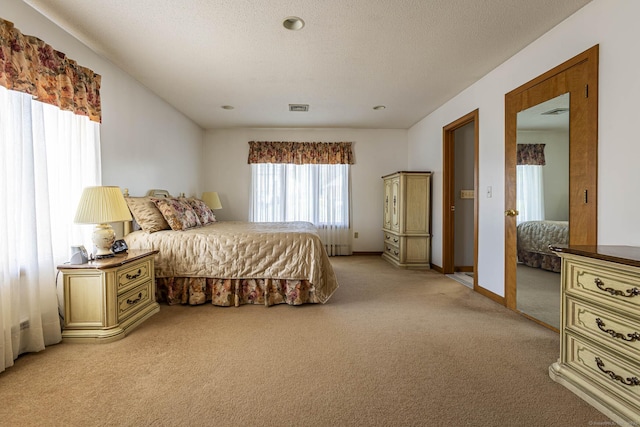 bedroom featuring baseboards, visible vents, and light carpet