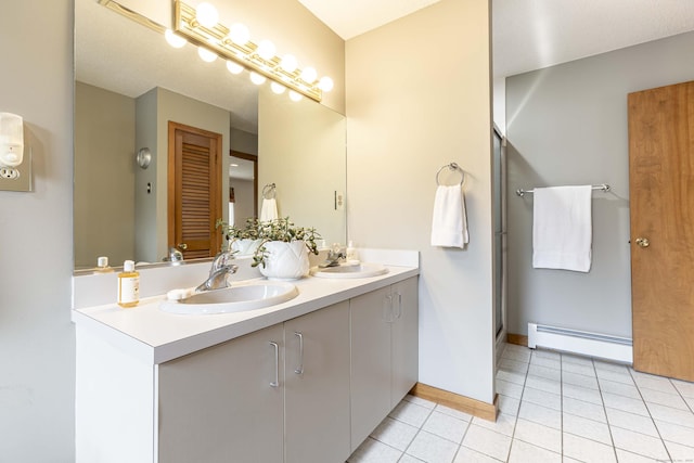 full bathroom featuring double vanity, tile patterned flooring, a baseboard heating unit, and a sink
